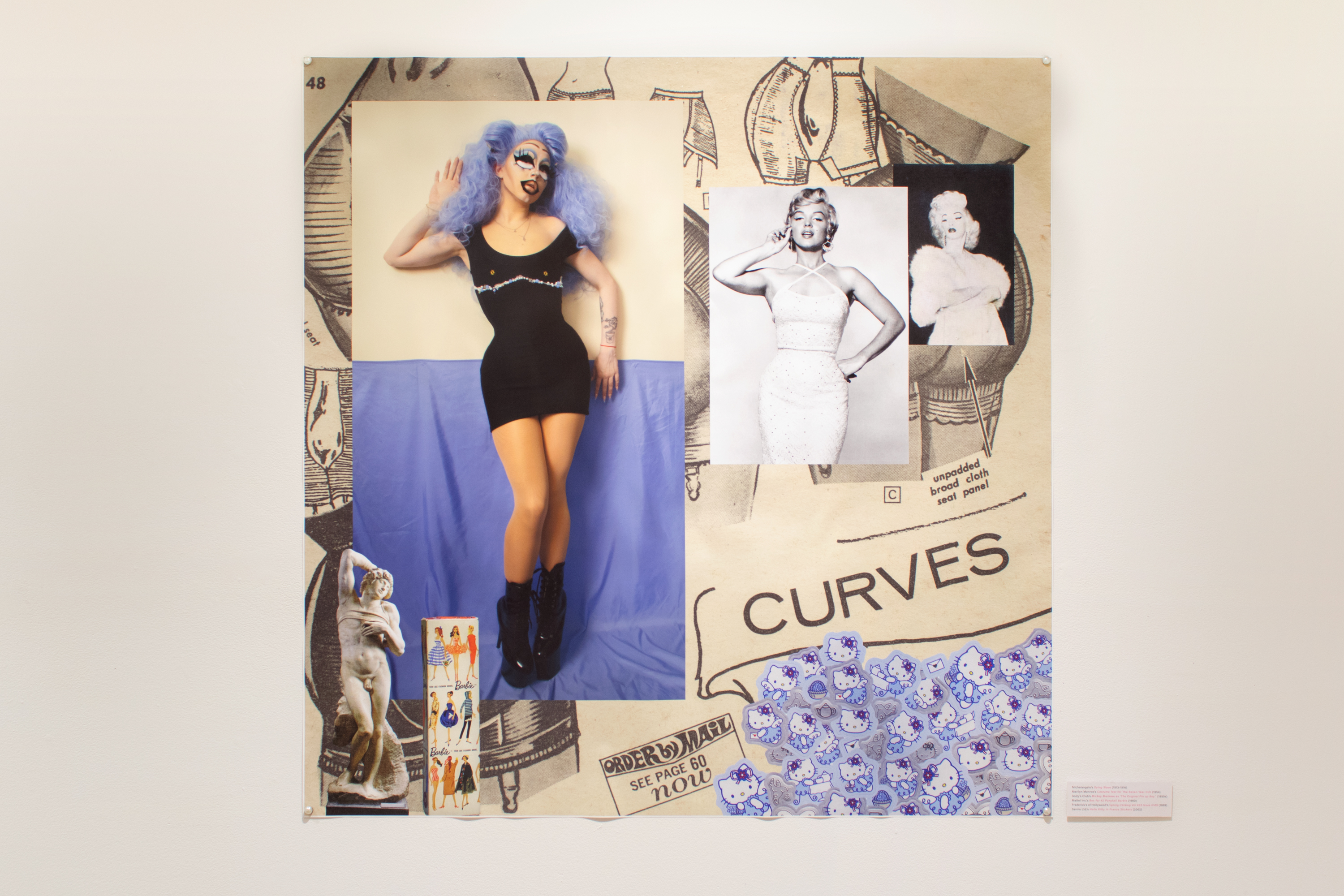 installation view of a photomontage of the artist in high femme drag with imagery about the portrayal of 'curves' in art and fashion surrounding her