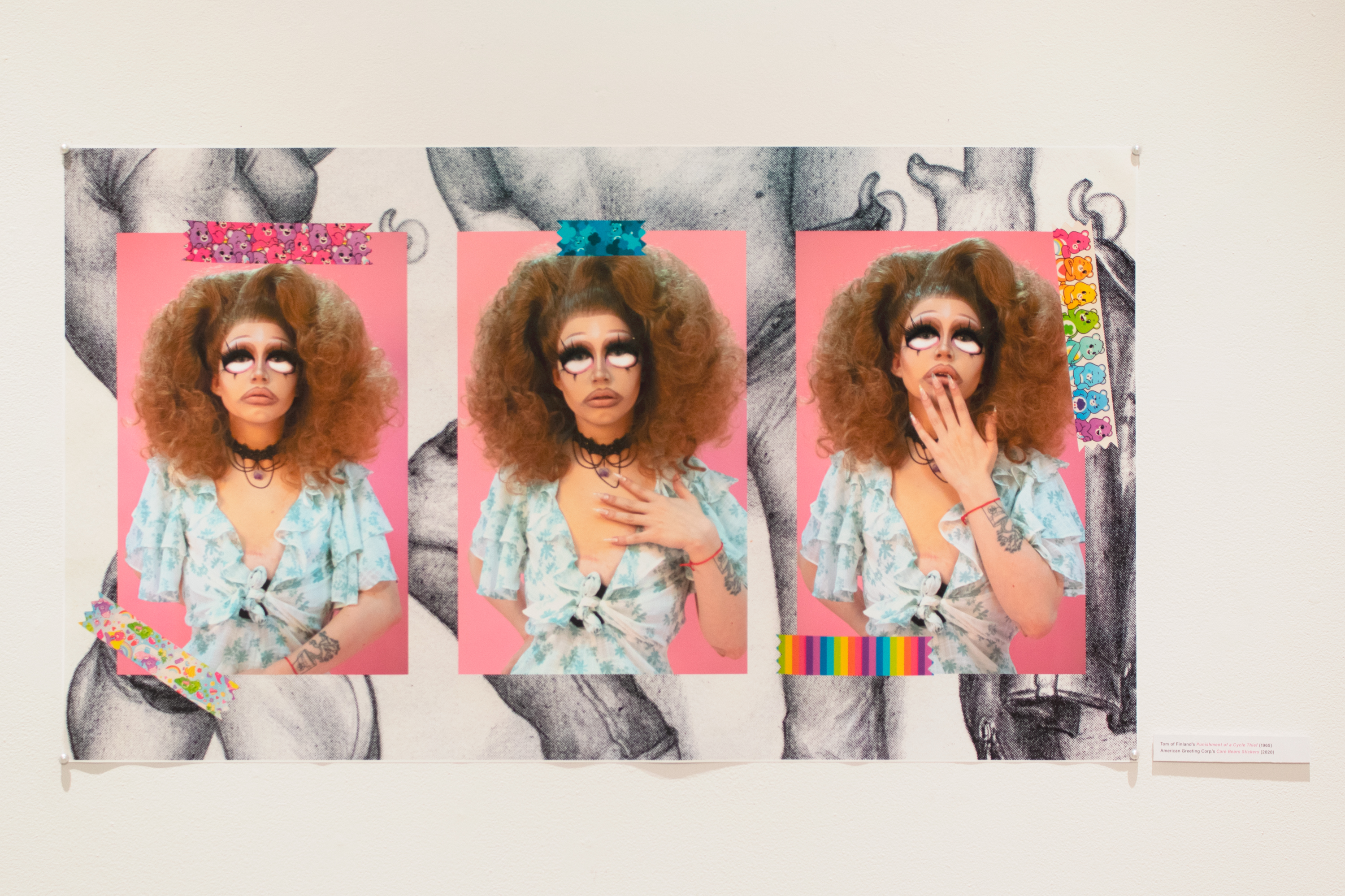 installation view of a photomontage of three images of the artist in high femme drag with a tom of finland drawing as the background and carebear stickers